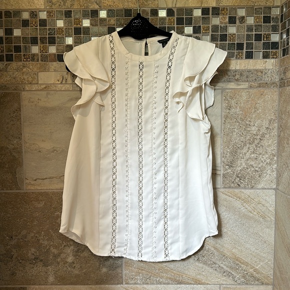 White with short ruffle sleeve and see through detail down the front. - Picture 1 of 2